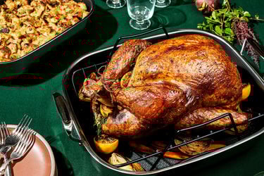 Turkey sits in HexClad Large Roasting Pan on table with green tablecloth
