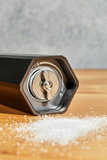 heavy duty salt grinder seasoning fresh broccoli on a HexClad cutting board