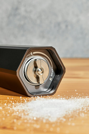 heavy duty salt grinder seasoning fresh broccoli on a HexClad cutting board