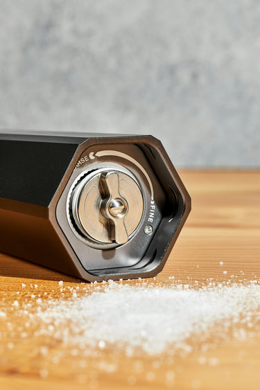 heavy duty salt grinder seasoning fresh broccoli on a HexClad cutting board